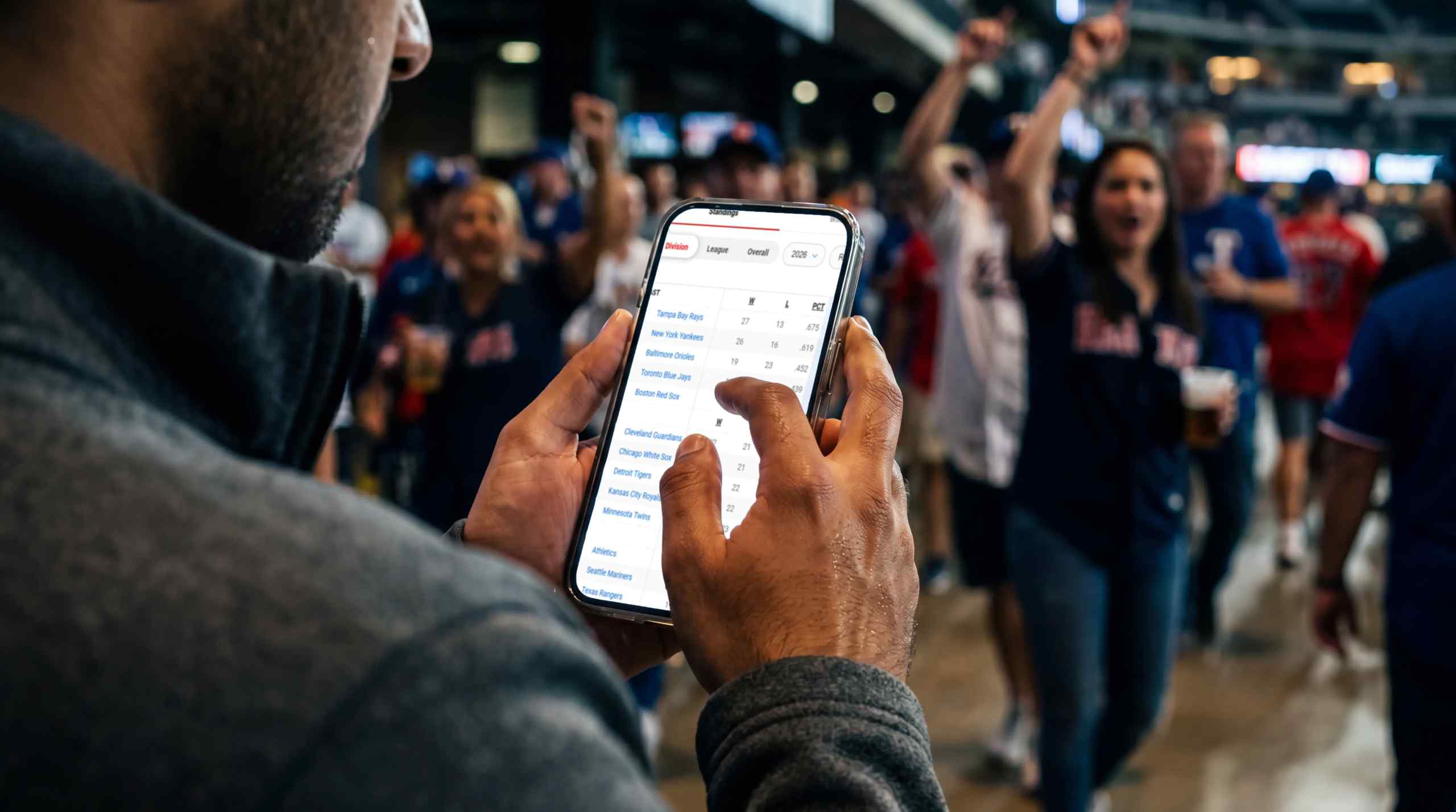 A man looks at the current standings of the MLB on his phone.